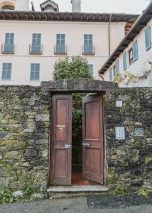 un muro di pietra con due porte davanti a un edificio di L&B HOUSE a Orta San Giulio