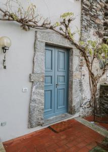 una porta blu sul lato di un edificio di L&B HOUSE a Orta San Giulio