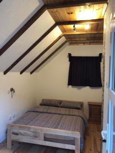 Private accommodation Kalezić في مويكوفاتش: غرفة نوم بسرير في غرفة بسقوف خشبية