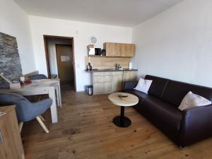 salon z czarną kanapą i stołem w obiekcie Ferienwohnung Margareta w mieście Bad Goisern