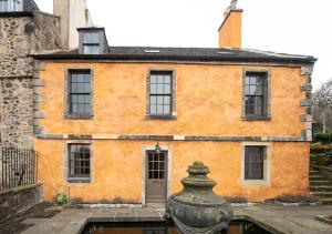 an old orange building with windows and a fountain at The Rock House - Terrace Apartment - in Heart of the City in Edinburgh