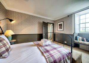 a bedroom with a bed with a plaid blanket at The Rock House - Terrace Apartment - in Heart of the City in Edinburgh