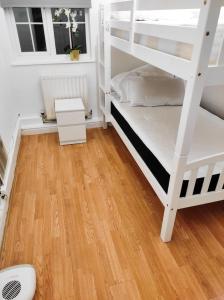 a bedroom with two bunk beds and a wooden floor at pinner apartments in Pinner