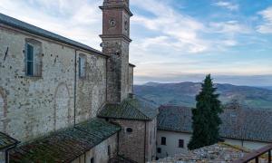 a clock tower on the side of a building at La Torre del Conte,Free Wi-fi, Amazing view in Montepulciano