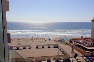 ein Blick auf einen Strand mit Menschen am Strand in der Unterkunft Depto. frente a la playa con hermosa vista al mar y faro La Serena in La Serena