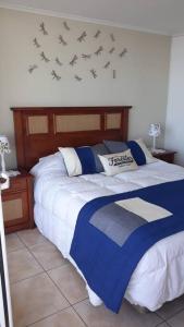 a bedroom with a bed with birds on the wall at Depto. frente a la playa con hermosa vista al mar y faro La Serena in La Serena