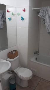 ein kleines Badezimmer mit Toilette und Waschbecken in der Unterkunft Depto. frente a la playa con hermosa vista al mar y faro La Serena in La Serena + 7 Fotos