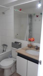 ein weißes Badezimmer mit Toilette und Waschbecken in der Unterkunft Depto. frente a la playa con hermosa vista al mar y faro La Serena in La Serena