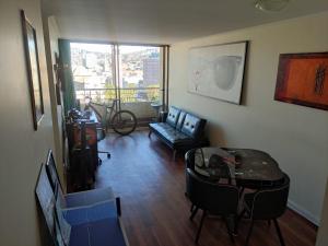 sala de estar con sofá, mesa y sillas en Habitación Privada Valparaíso Depto Compartido, en Valparaíso