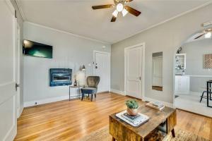 a living room with a ceiling fan and a table at The Dreamy Escape on Lower Greenville in Dallas