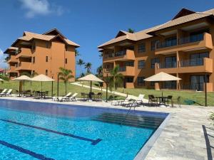 ein Resort mit einem Pool mit Stühlen und Sonnenschirmen in der Unterkunft ECO RESORT PRAIA DOS CARNEIROS - NOVÍSSIMO in Tamandaré