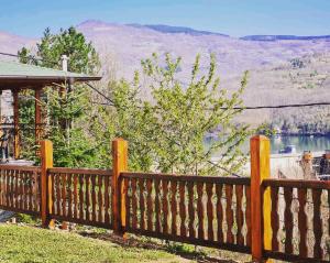 a wooden fence with a view of a lake at Apartmani RESET DRINA in Bajina Bašta