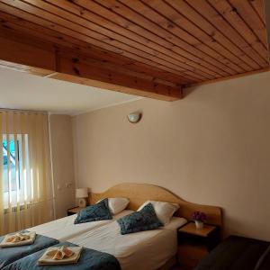 a bedroom with two beds and a wooden ceiling at Guest House Planinski Zdravets in Bansko