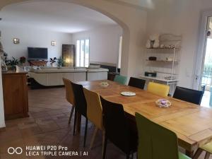 a dining room and kitchen with a wooden table and chairs at Chez TATA in Régusse