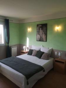 a bedroom with a large bed with green walls at Chez TATA in Régusse