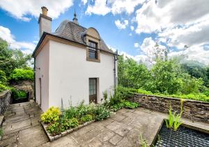 a white house with a roof and a garden at Rock House - Photographer's Studio - Historic Gem in the heart of the City in Edinburgh