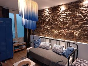 ein Zimmer mit einer Steinmauer und einer Couch mit Kissen in der Unterkunft Studio jazz in Vienne