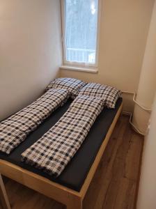 1 cama con 2 almohadas en una habitación en Apartmán v Desné, en Desná