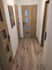 una stanza vuota con due porte e un pavimento in legno di Apartmán v Desné a Desná