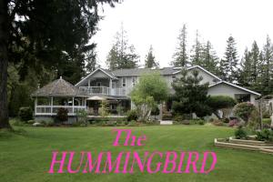 uma casa com um sinal que lê o martelo em Hummingbird Guesthouse em Port Alberni