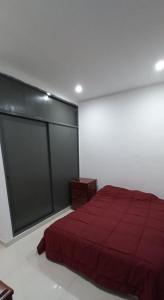 1 dormitorio con 1 cama con manta roja en Dpto estrada en Ezeiza