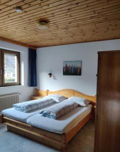 2 Betten in einem Schlafzimmer mit Holzdecke in der Unterkunft Landhaus Penker in Mallnitz
