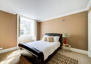 a bedroom with a black leather bed and a window at Super central Edinburgh Castle basement in Edinburgh