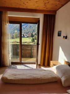 ein Schlafzimmer mit einem Bett und einem großen Fenster in der Unterkunft Landhaus Penker in Mallnitz