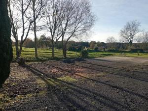 a dirt road with trees in a field at Loue gîte de campagne 