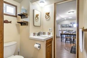 a bathroom with a sink and a toilet and a kitchen at Cozy Arroyo Grande Cottage with Patio and Grill! in Arroyo Grande
