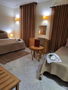 Habitación de hotel con 2 camas y mesa en HOTEL LAFAYETTE, en Túnez