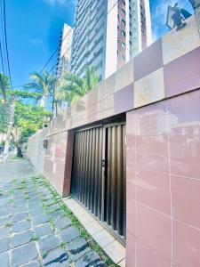 un edificio rosa en una calle con edificios altos en Pousada E Hostel Pernambucana, en Recife