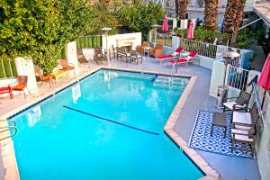 a large swimming pool with chairs and a table at Inn at Palm Springs in Palm Springs