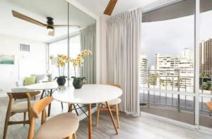 a dining room with white tables and chairs and a large window at Ilikai Marina Vacations in Honolulu