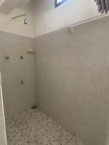 a bathroom with a shower stall and a tiled floor at Posada Xtakay Bacalar ''Turix'' in Bacalar