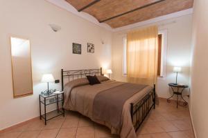 1 dormitorio con 1 cama, 2 lámparas y ventana en Agriturismo Podere Camollia, en Costalpino