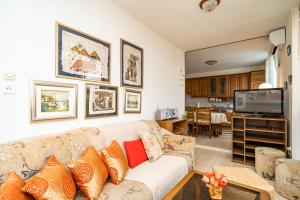 a living room with a couch and a tv at SPACIOUS THREE BEDROOM APARTMENT in Dubrovnik