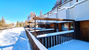 un edificio cubierto de nieve con una valla en Residence Edelweiss Ciel Blu en Pila