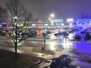 um parque de estacionamento com carros estacionados em frente a uma loja em Apartment near Akropolis em Klaipėda