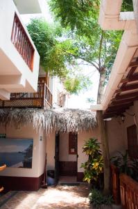 a building with a thatch roof and a balcony at Hotel Susibon in Olón