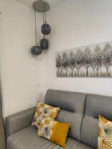 a living room with a gray couch and two lights at M&D Centro Málaga in Málaga
