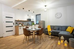 a kitchen and a living room with a table and a couch at Szary Domek in Janowice Wielkie