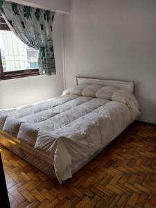 1 cama grande en un dormitorio con ventana en Departamento Oro 2428 en Buenos Aires
