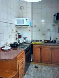y cocina con fogones y microondas. en Departamento Oro 2428 en Buenos Aires