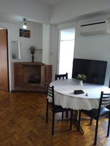 sala de estar con mesa, sillas y chimenea en Departamento Oro 2428 en Buenos Aires