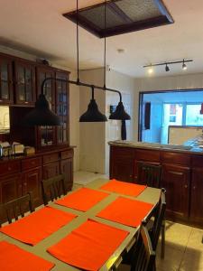 a kitchen with a table with orange mats on it at Casa Alba in Mindelo