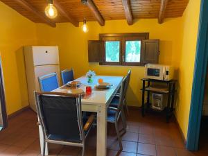 a kitchen with yellow walls and a table and chairs at Oasi Del Fiumefreddo in Fiumefreddo di Sicilia