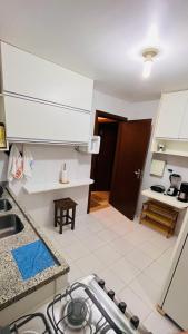 a kitchen with a sink and a stove top oven at Casa Peixinho - Reserva Imbassaí 3 suítes in Imbassai