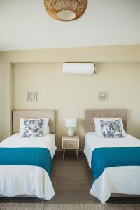 1 dormitorio con 2 camas y mesa con lámpara en Kokoa Hotel Vichayito, en Vichayito