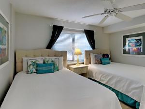 a bedroom with two beds and a window at Sandy Key #223 in Perdido Key +19 photos